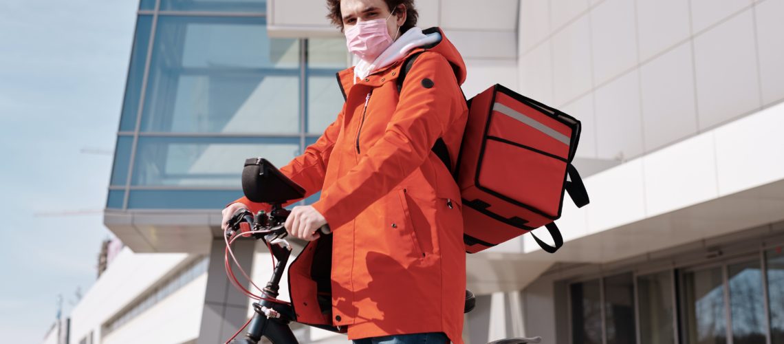 delivery-man-wearing-a-face-mask-and-riding-a-bicycle-4392039
